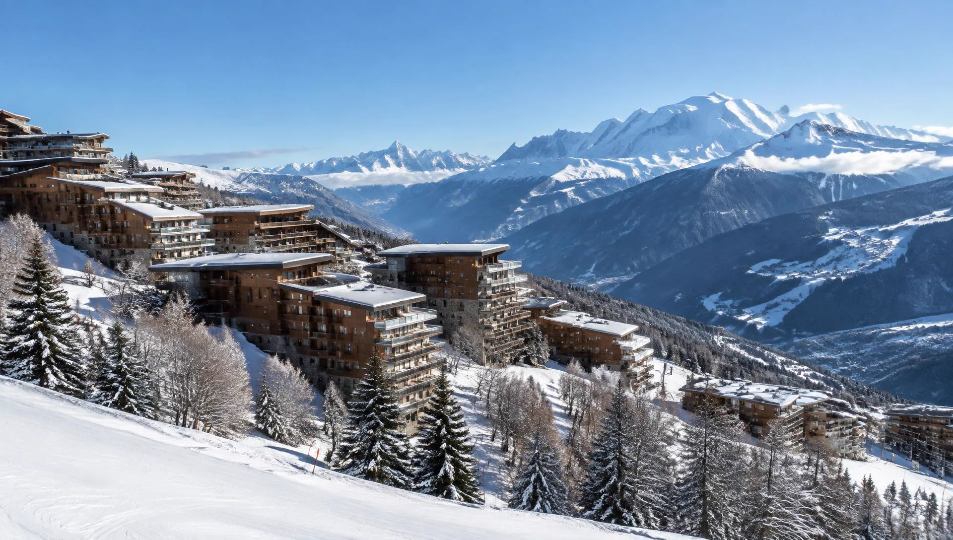 Station des Arcs en hiver avec ses résidences sur les pentes enneigées et le Mont-Blanc au loin
